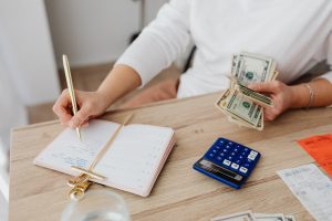 Woman holding cash budgeting Penny Forward woman making a budget